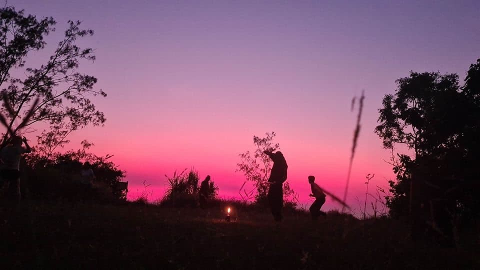 Free-dance community moving together at sunset beside the sea
